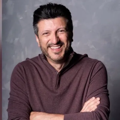 A man smiles broadly out at the camera. He has short dark hair and a neat, short beard. This is Lito Sousa.